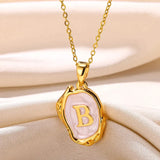 Colier ocean cu inițiale placate cu aur de 18 karate pe fundal marin